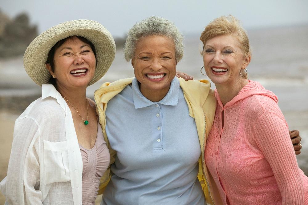 three ladies smiling outside | dental implants bloomington in