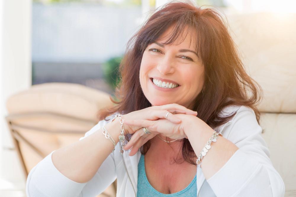 woman with brown hair smiling | dental crowns bloomington in