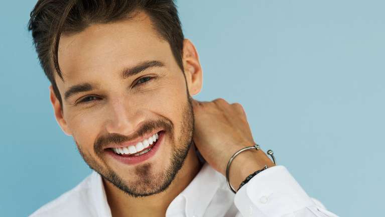 man in white shirt smiling | dentist bloomington indiana