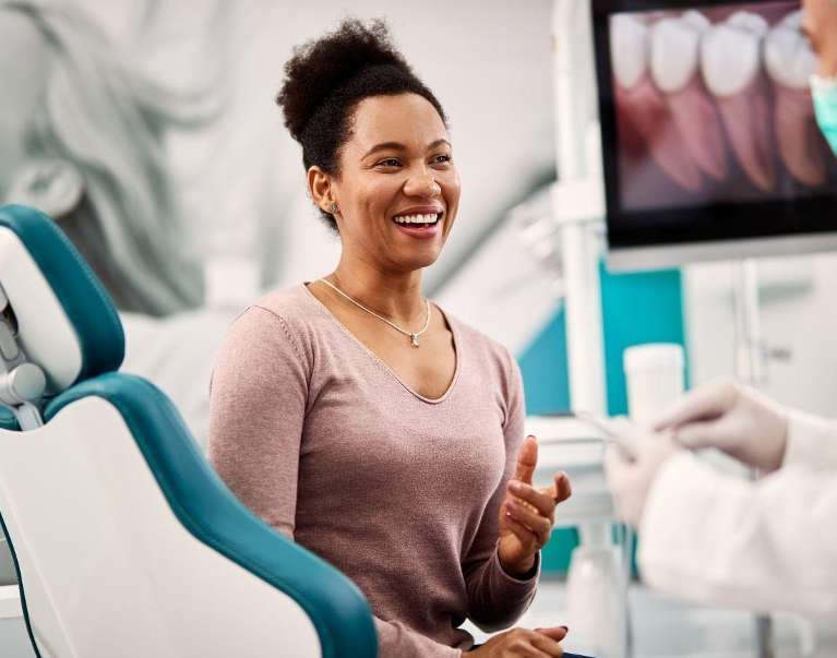 A woman smiling brightly after procedure for porcelain veneers in Bloomington, IN.