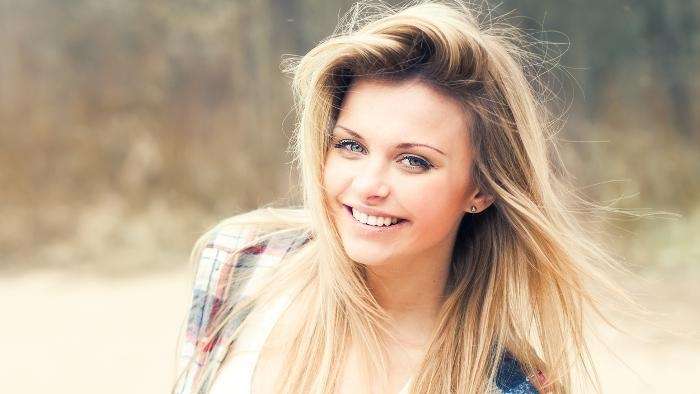 blonde woman smiling | dental crowns bloomington in
