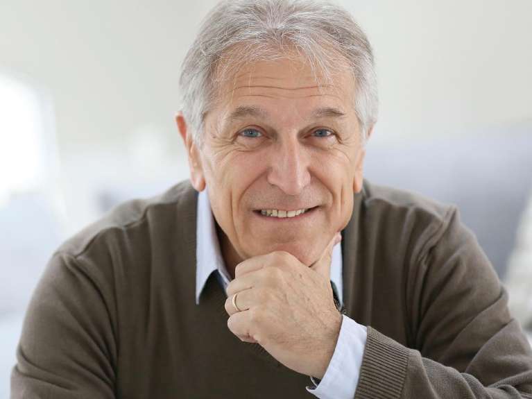 Man smiling confidently after dental implant tooth replacement in Bloomington, IN