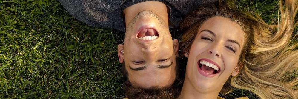 young couple laying on grass | dentist bloomington indiana