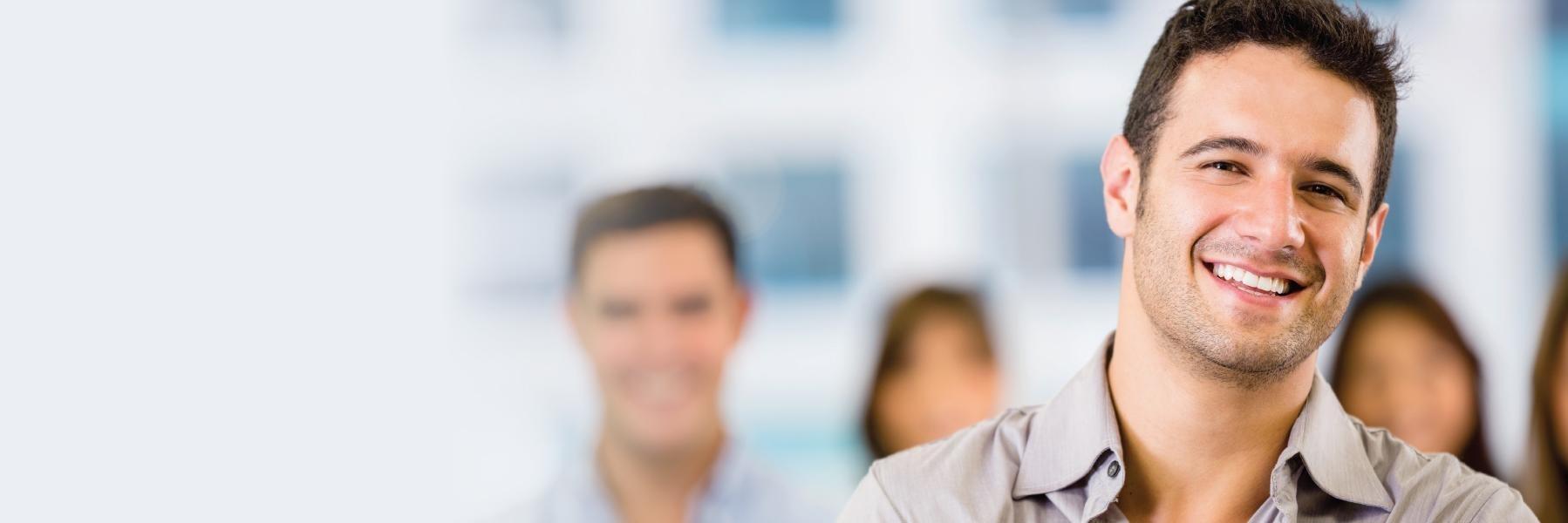 man with brown shirt smiling l dentist in bloomington in