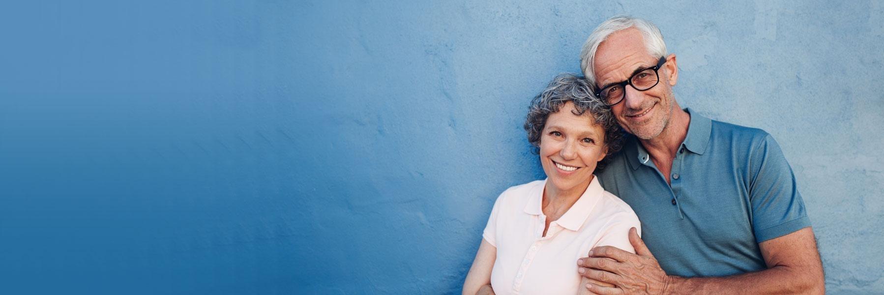 older couple with blue background l dentures bloomington in